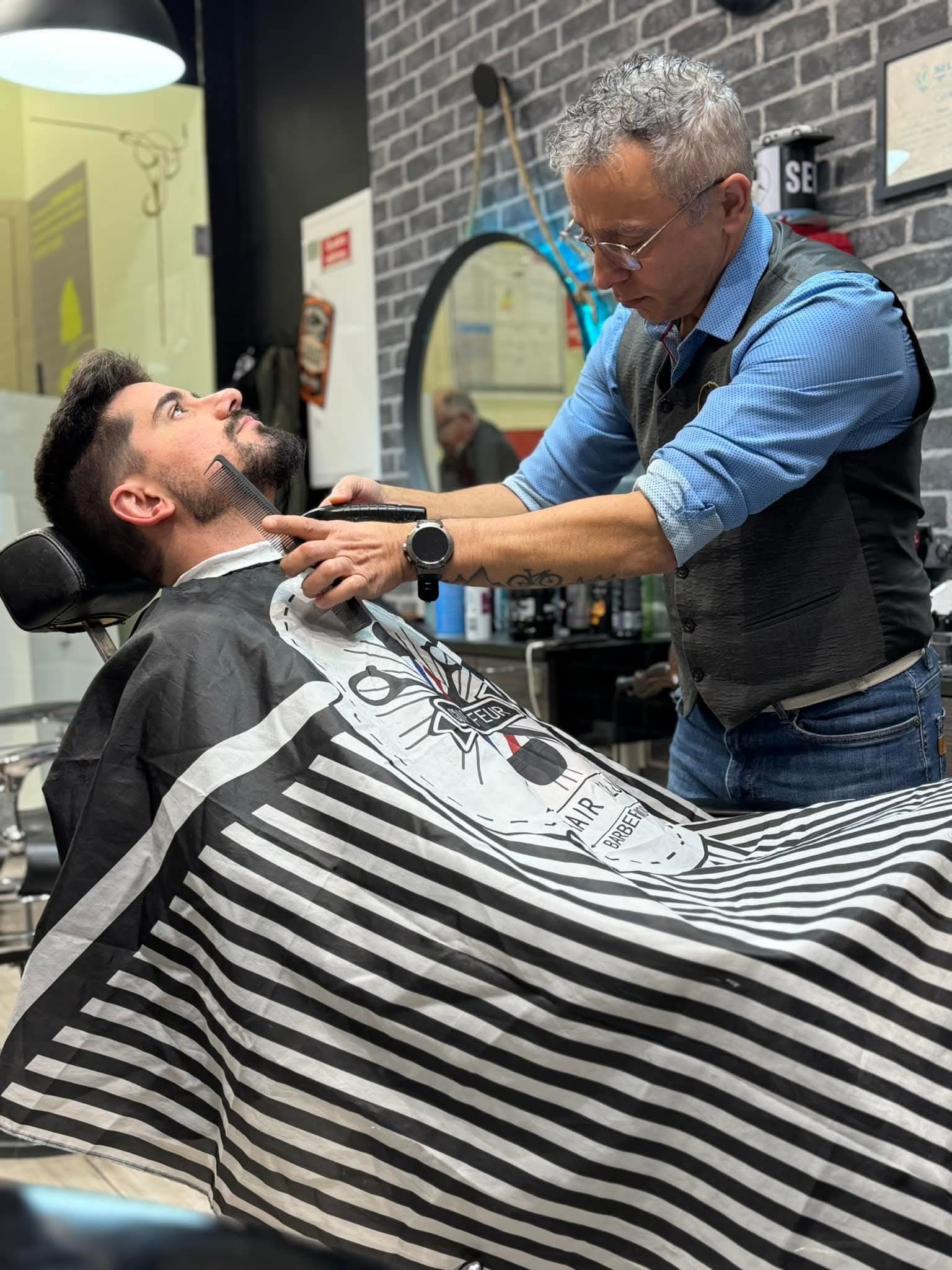 Barbeiro a aparar a barba de um cliente na Barbearia Sr. Dudu
